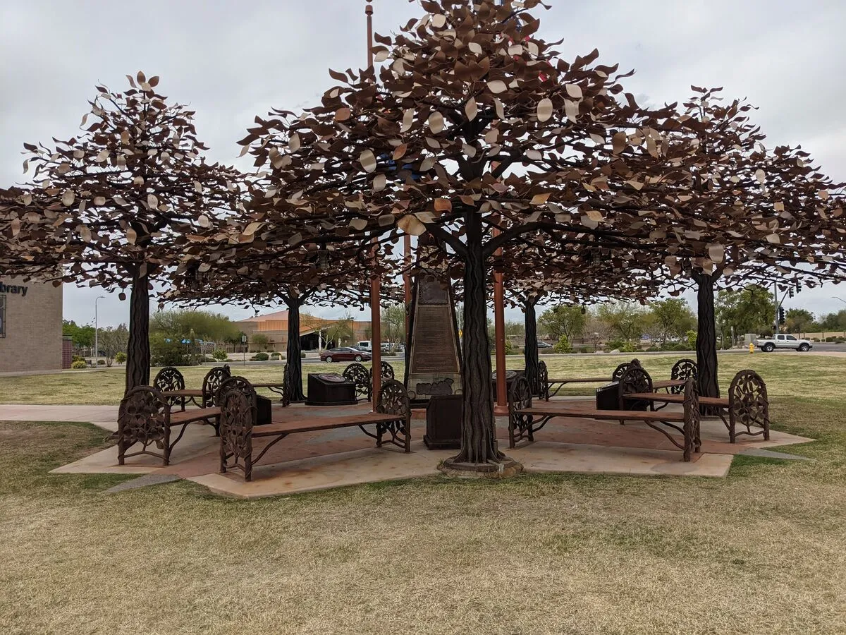 Metal tree sculptures with benches underneath at Glendale Xeriscape Demonstration Garden, a unique feature of Arizona Botanical Gardens showcasing sustainable landscape art.